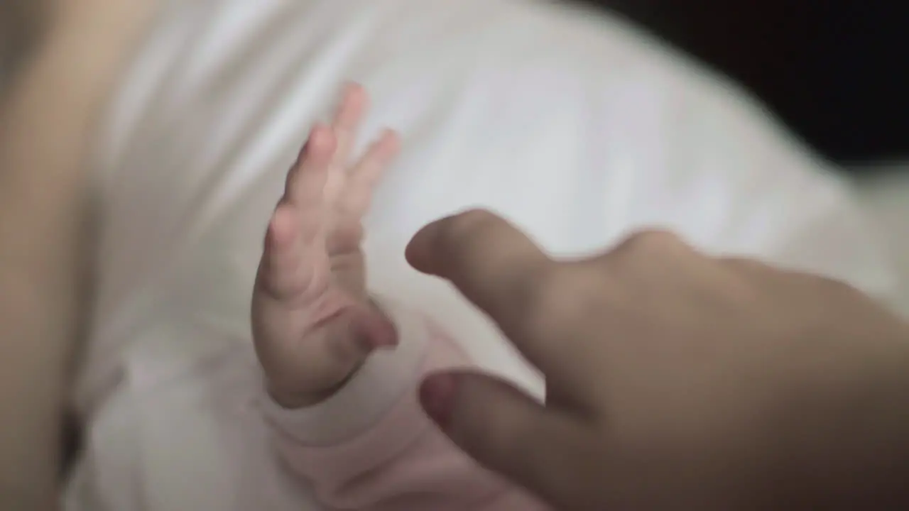 Maternal love Mother touching baby hand