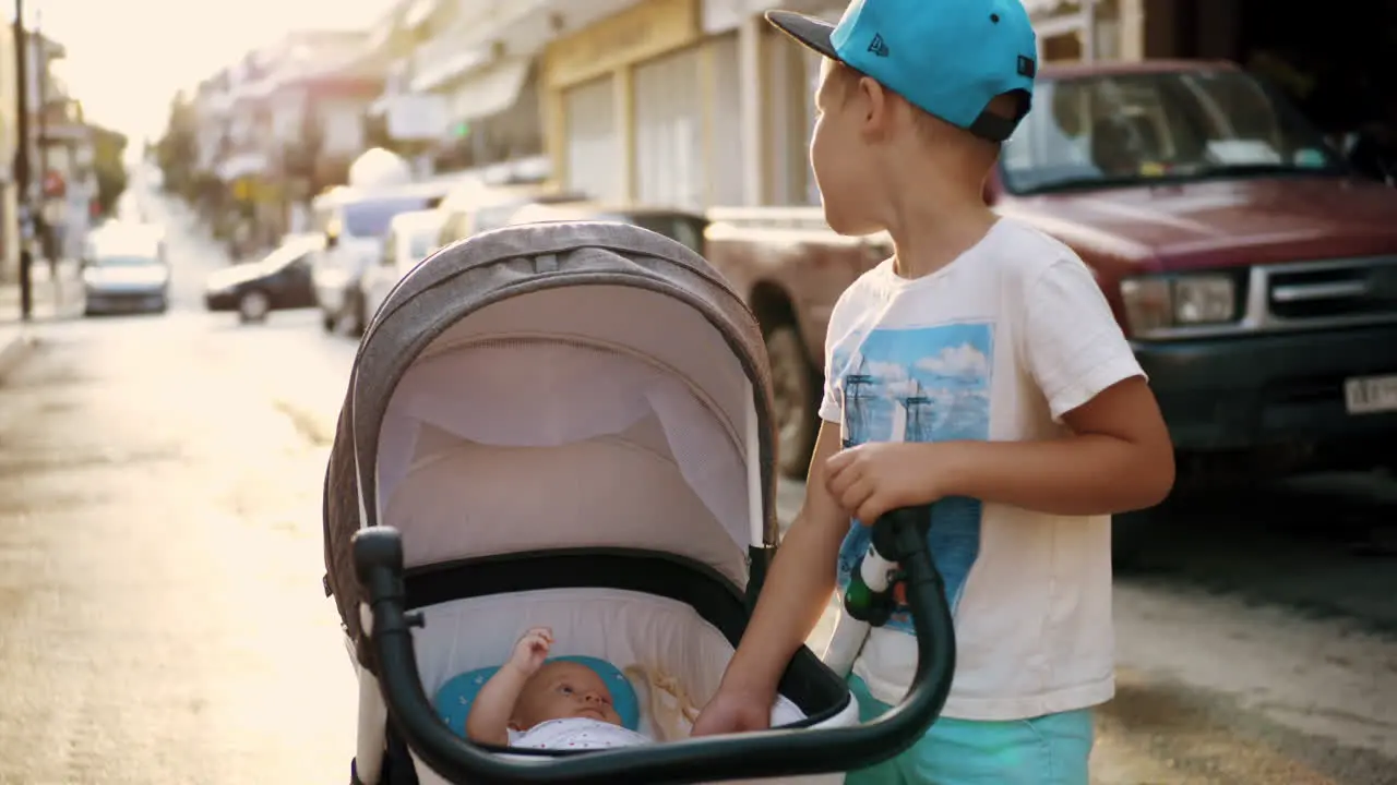 Elder brother looking after baby sister in the street