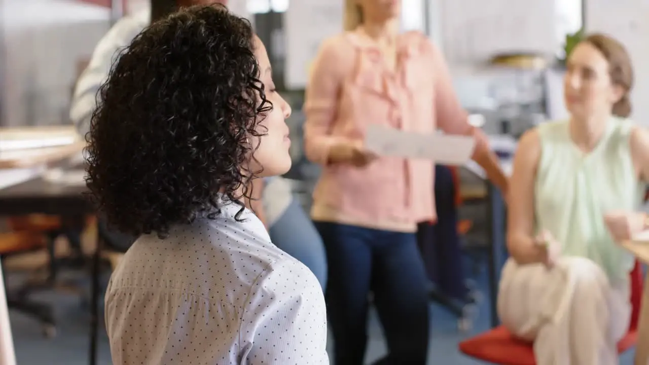 Portrait of biracial businesswoman with diverse colleagues at meeting slow motion