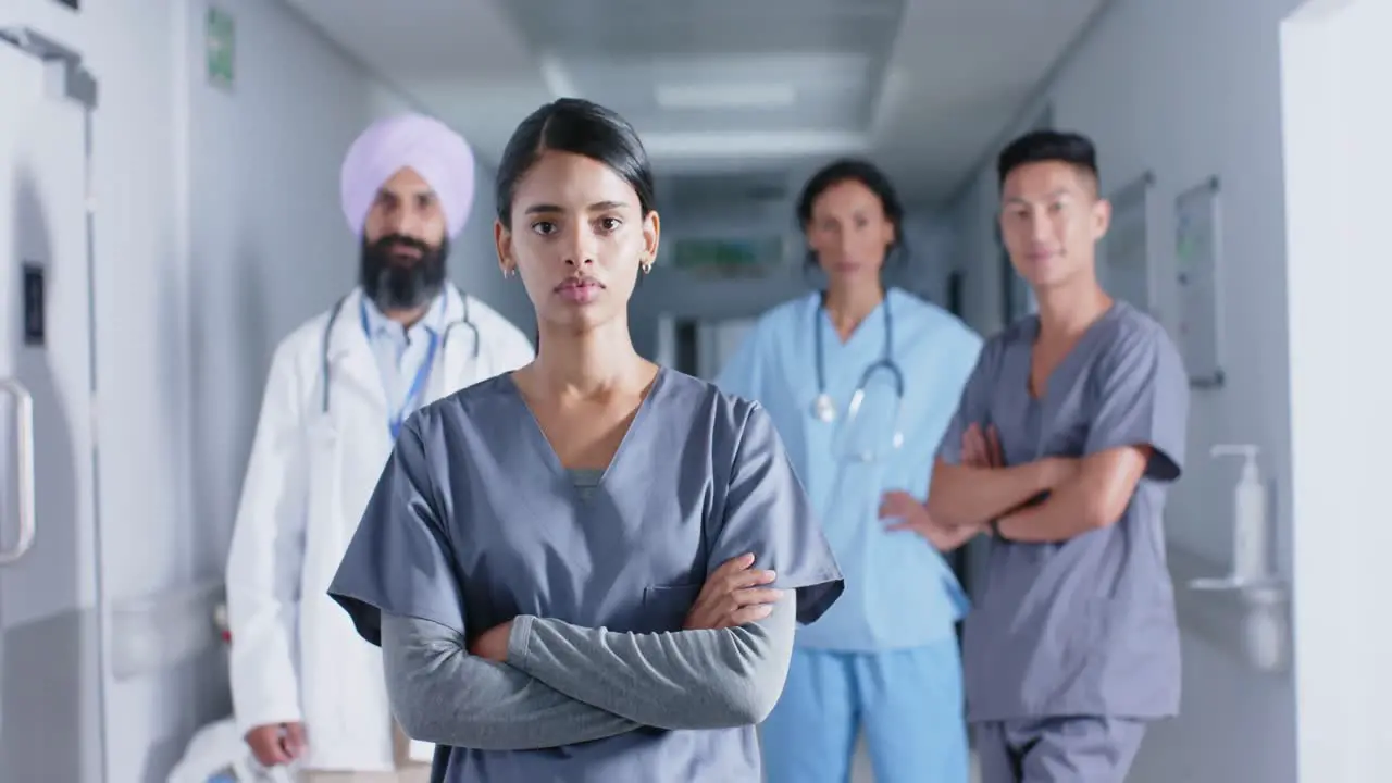 Portrait of diverse doctors and nurses in corridor at hospital in slow motion