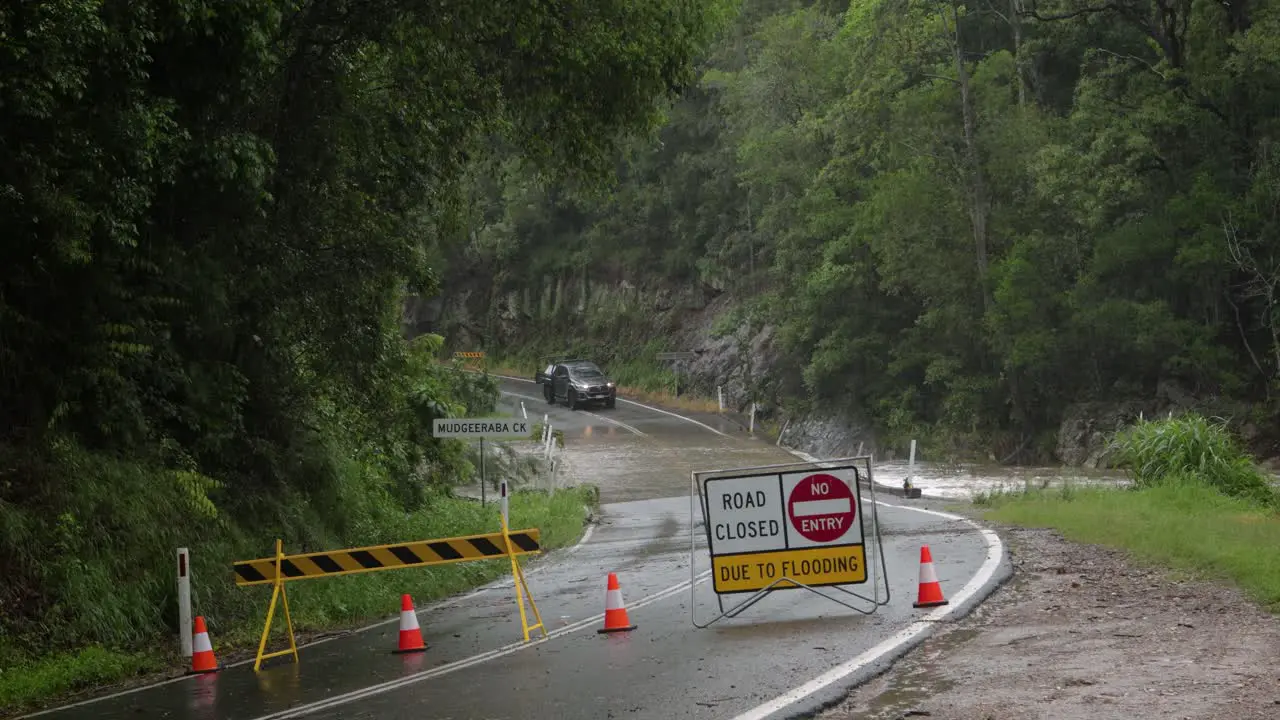 Mudgeeraba Gold Coast 02 January 2024 Car crossing Mudgeeraba Creek Bridge on the Gold Coast Hinterland during flooding