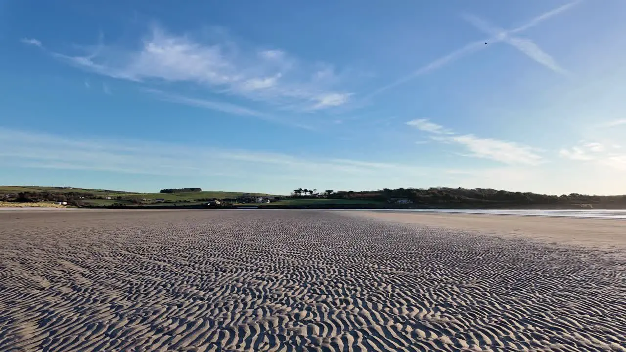 Empty sandy beach with frost and morning sun in Ireland