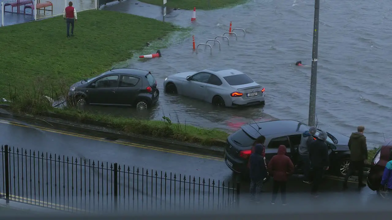 Group of people helping each other to rescue cars during the Storm Fergus