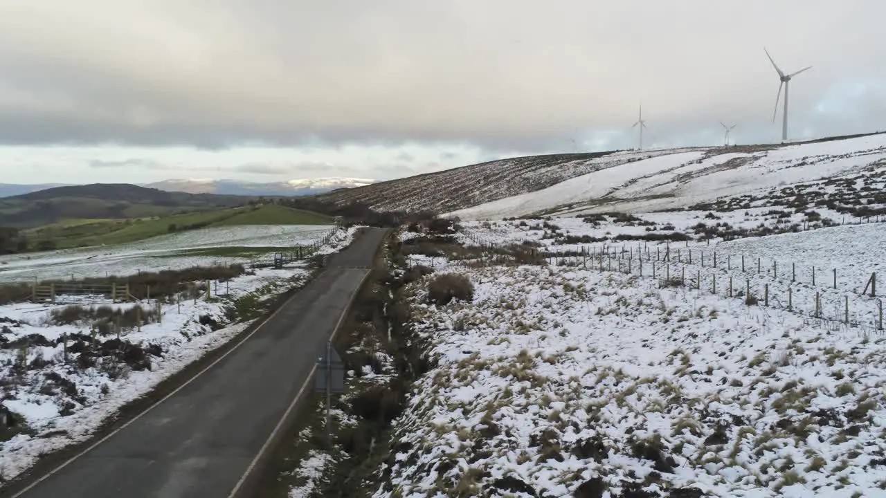 Snowy rural winter valley countryside aerial agricultural farmland landscape low slow push in