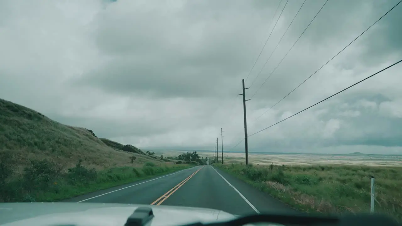 POV driving on a hawaiian road along power line on a cloudy day