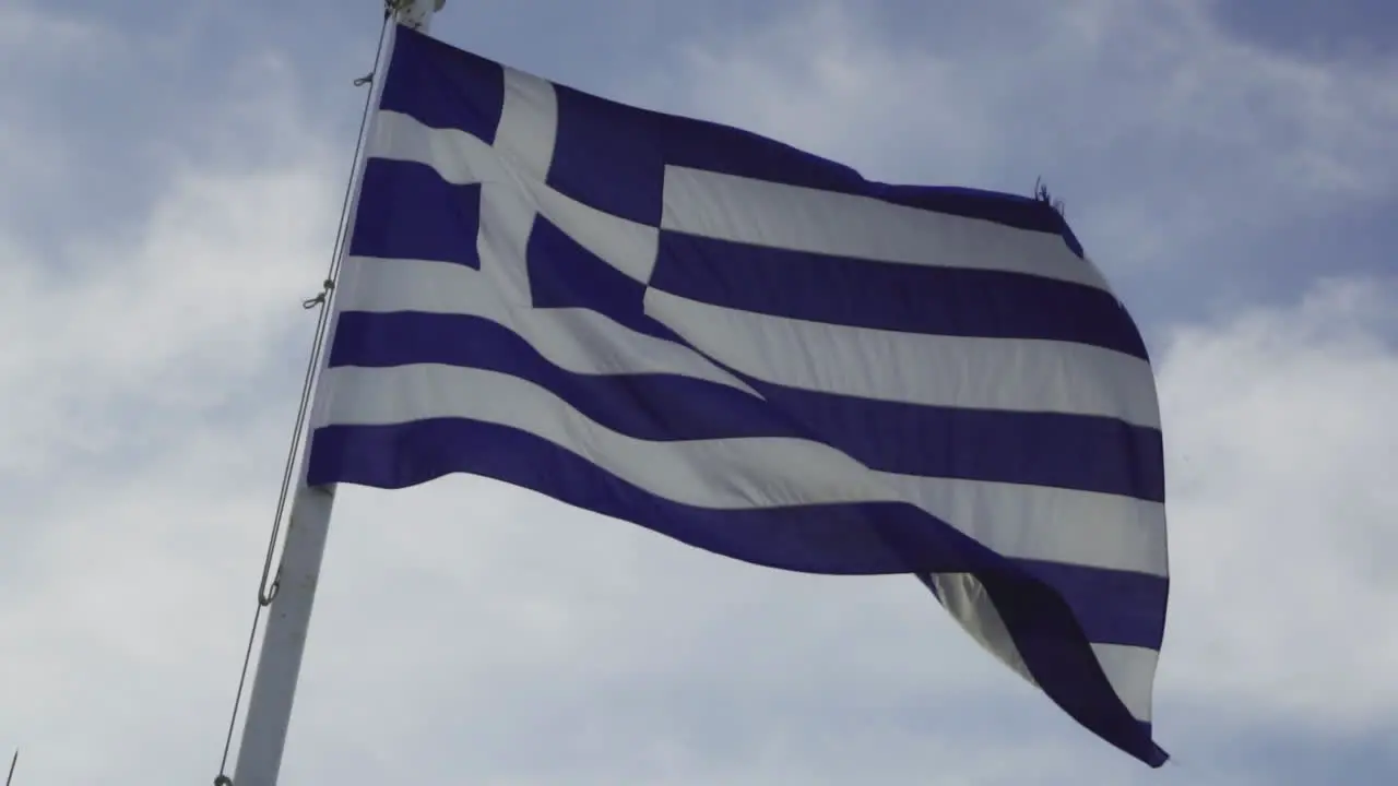 Greek flag slowly flapping in the wind on sunny day slow motion