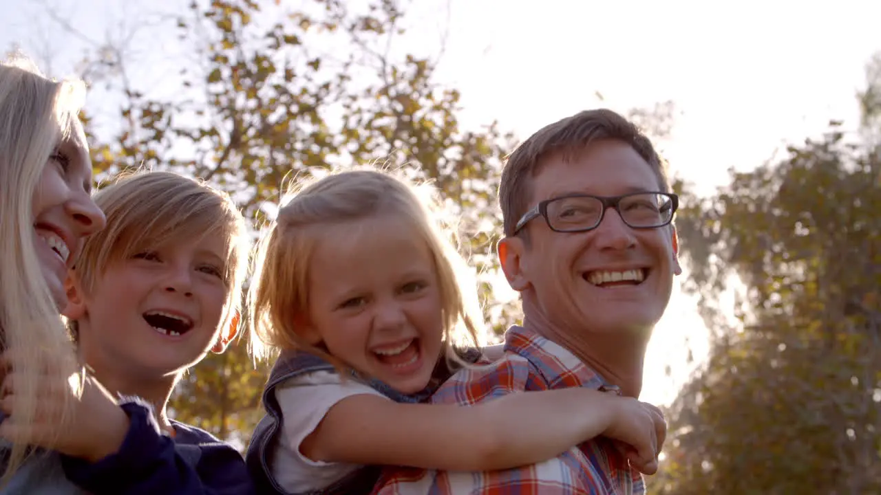 Young white family having fun piggbacking in a park