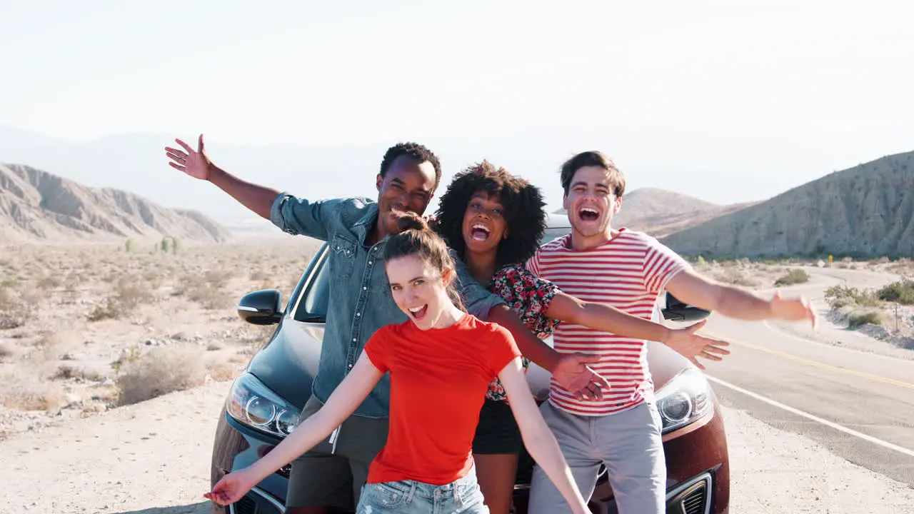 Young adult friends on road trip have fun posing by the car