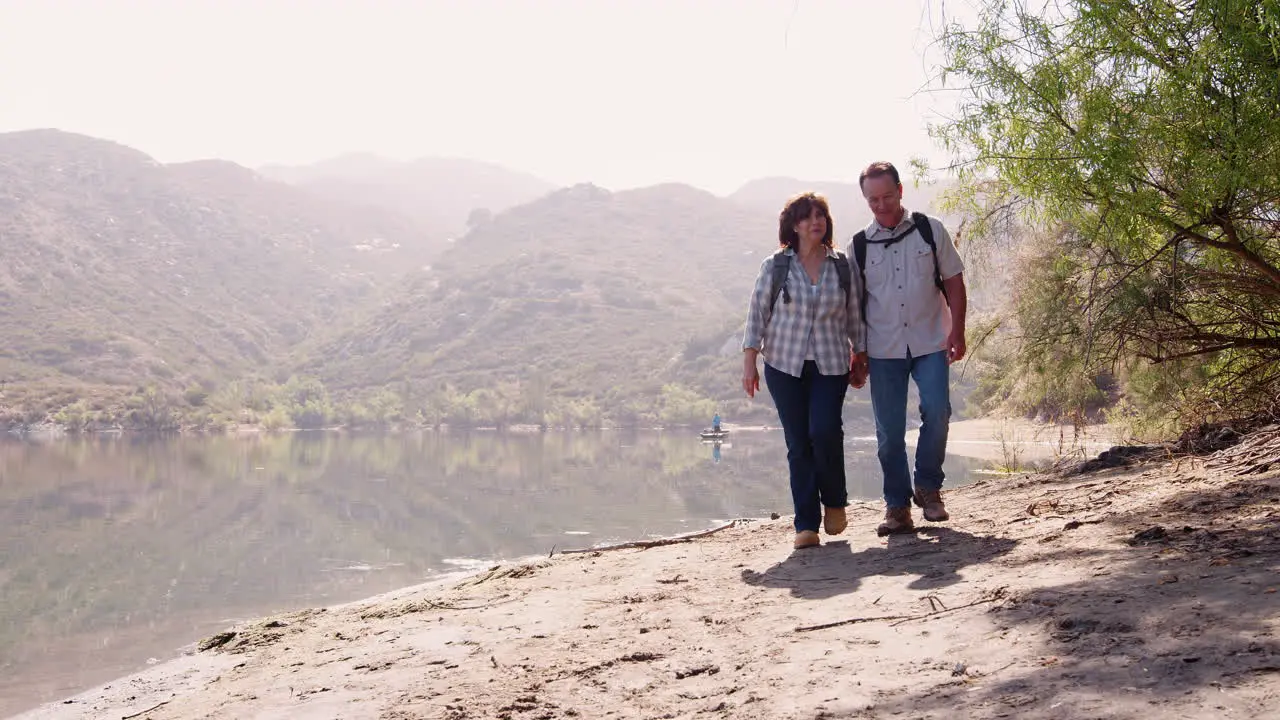 Senior couple hiking by a mountain lake