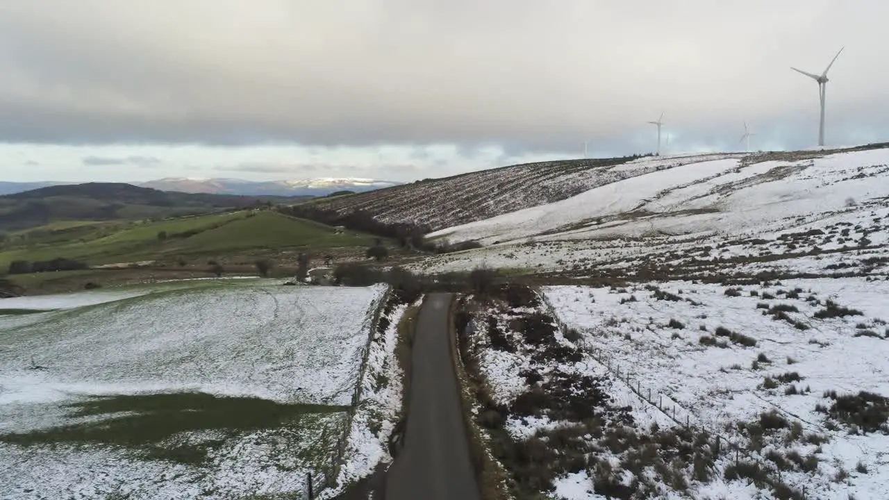 Snowy rural winter valley countryside aerial agricultural farmland highlands rising pull back