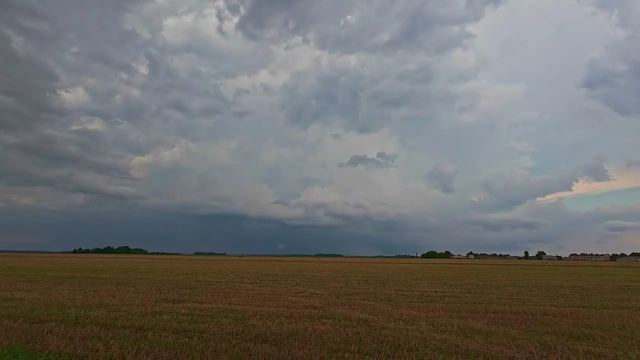 Cultivated fields under storm clouds moving through timelapse