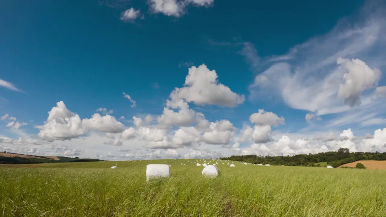 Movement of clouds and wind in the field with haylage roll silage time lapse clip