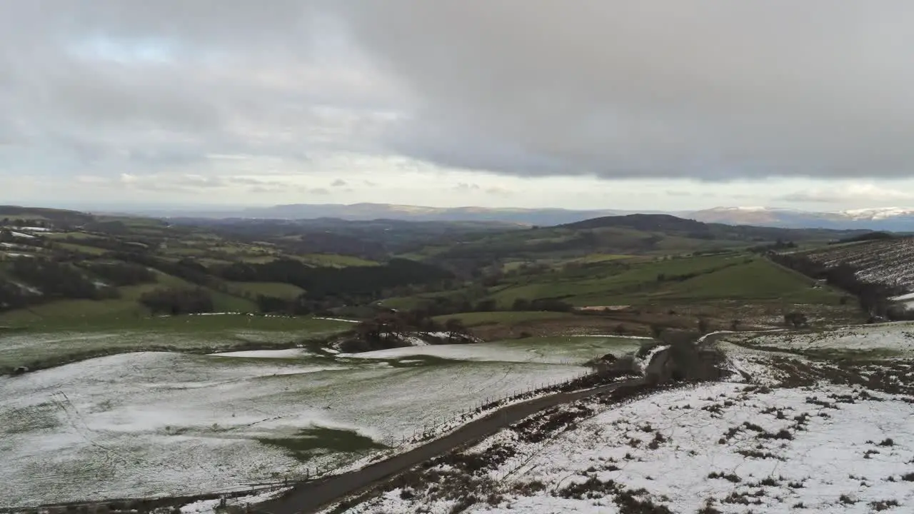 Snowy rural winter valley countryside aerial agricultural farmland landscape descent