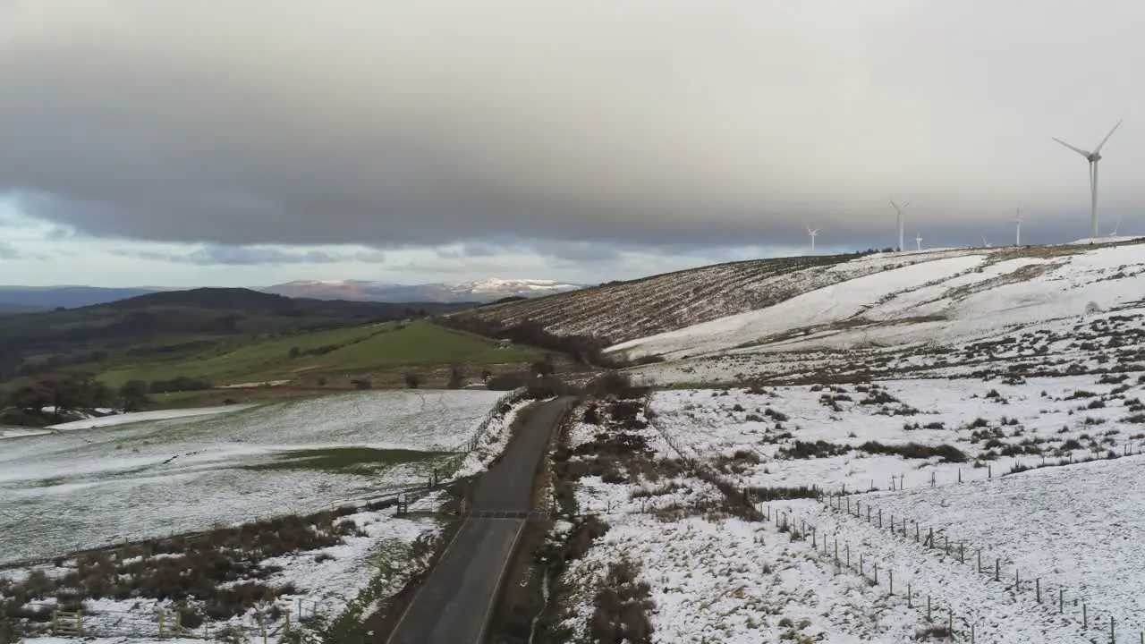 Snowy rural winter valley countryside aerial slow right pan agricultural farmland landscape