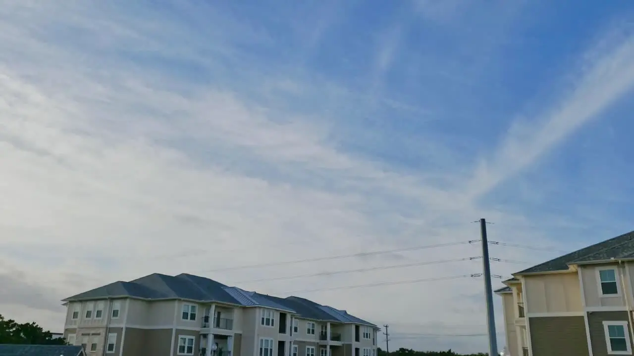 Time lapse of clouds moving over apartment complex clearing weather front revealing blue skies Texas