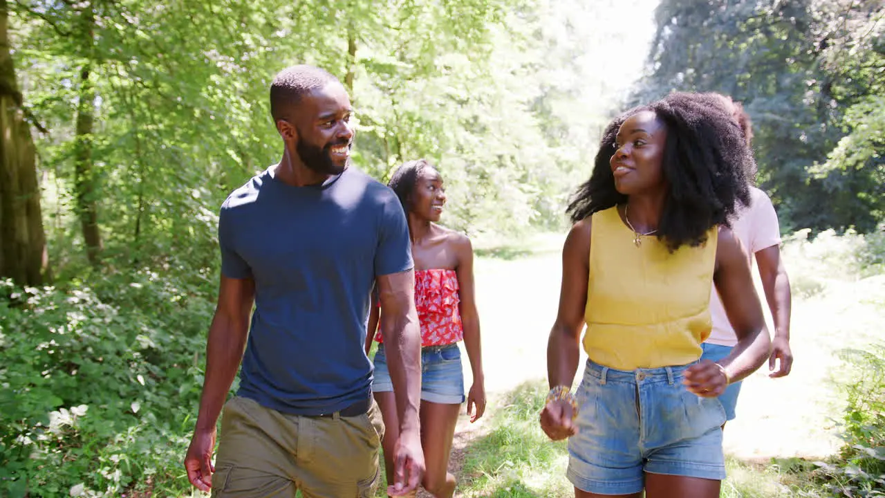 Two black couples walking together in woods close up