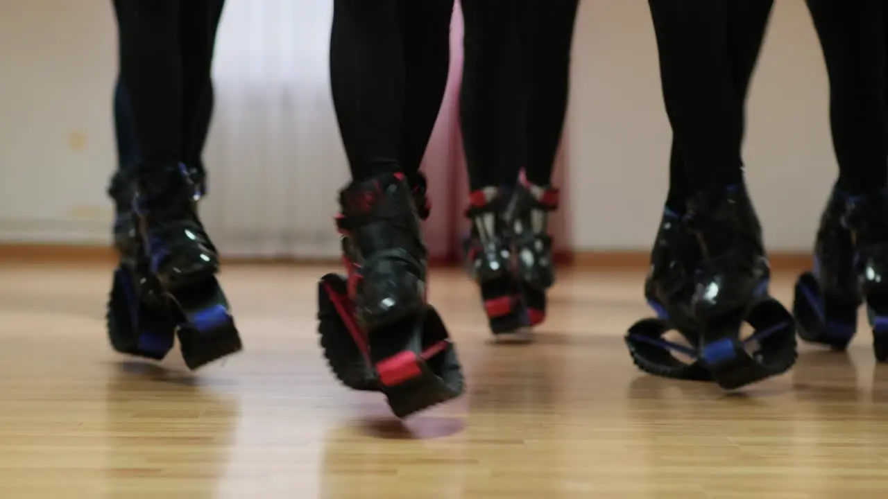 Sports girls perform synchronous jumps in the gym