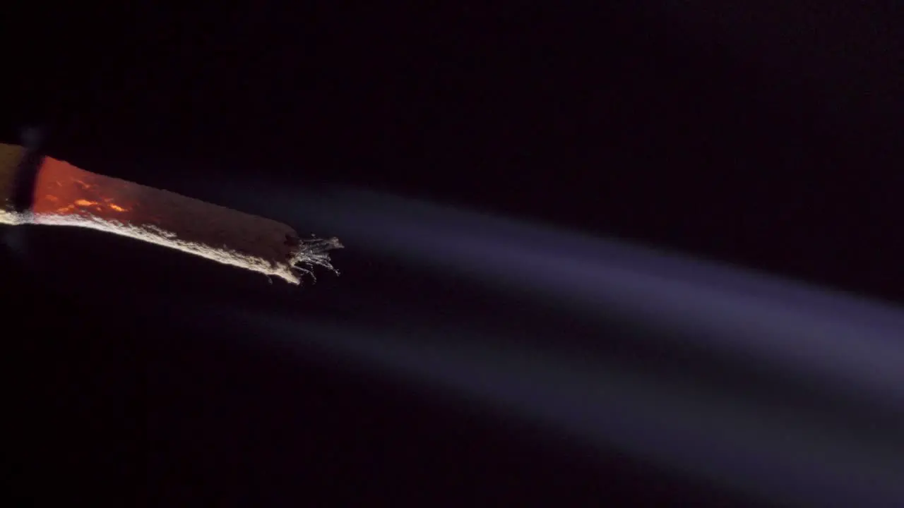 Burning incense stick smoking on simple dark black background macro copy space vertical footage