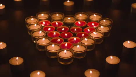 Romantic Red And White Candles In the Shape Of A Heart On Black Background