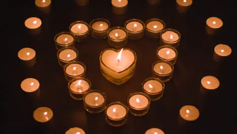 Romantic White Candles In the Shape Of A Heart On Black Background