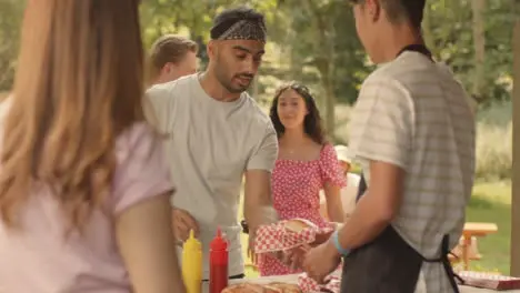 Long Shot of Festival Goer Getting a Hot Dog from Fast Food Stand