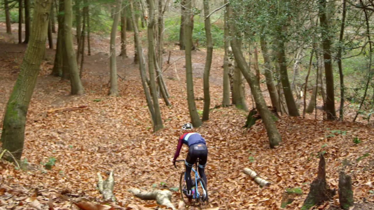 Young man cross-country cycling through a forest shot on R3D