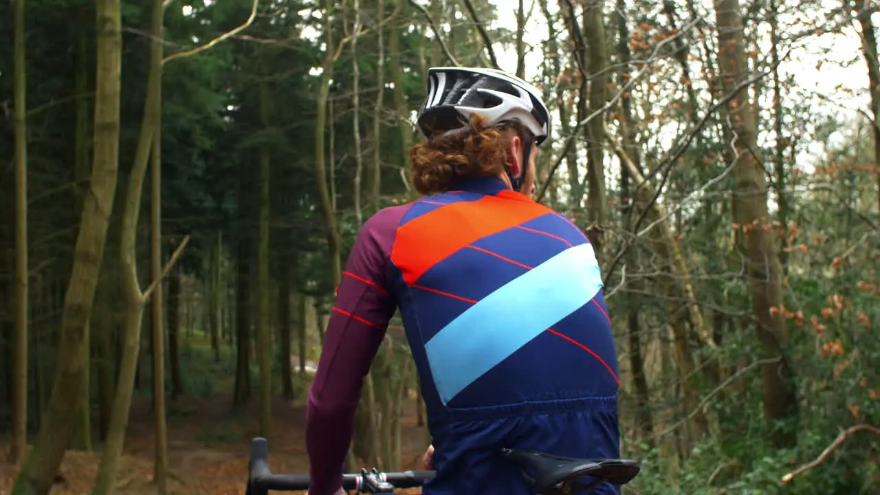 Cross-country cyclist resting and drinking on bike back view shot on R3D