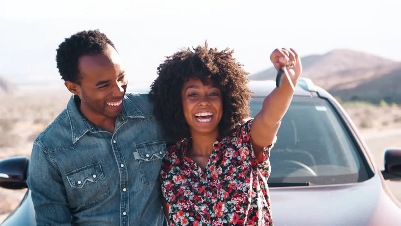 Young black having roadside stop off woman waving car keys