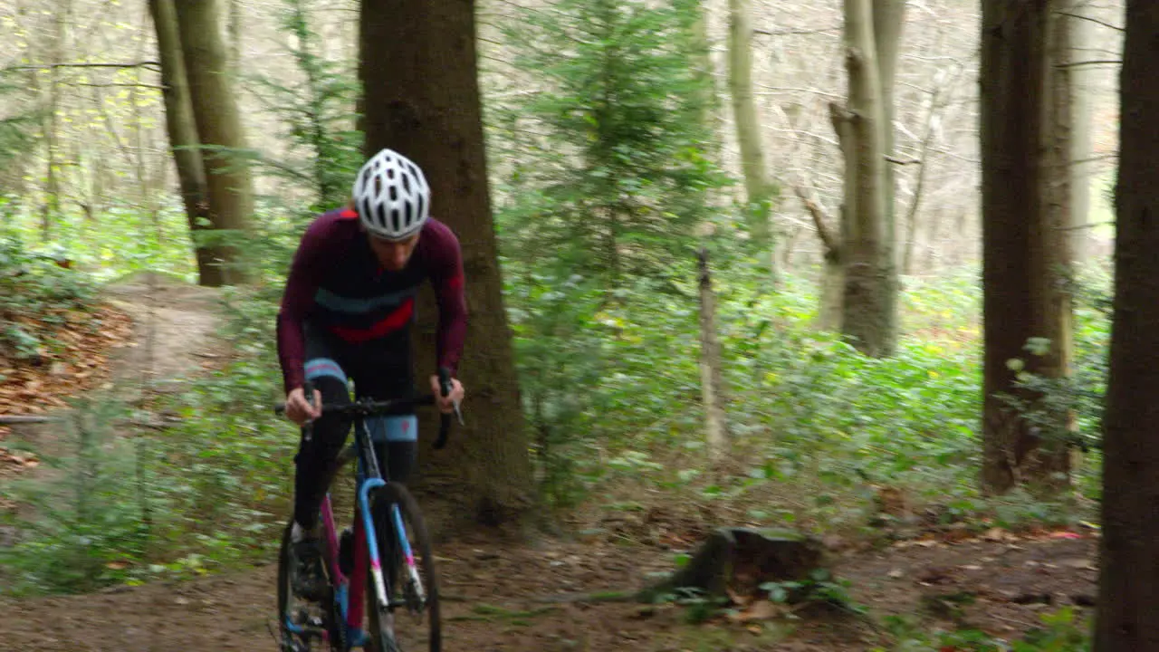 Young man cross-country cycling in forest front view shot on R3D