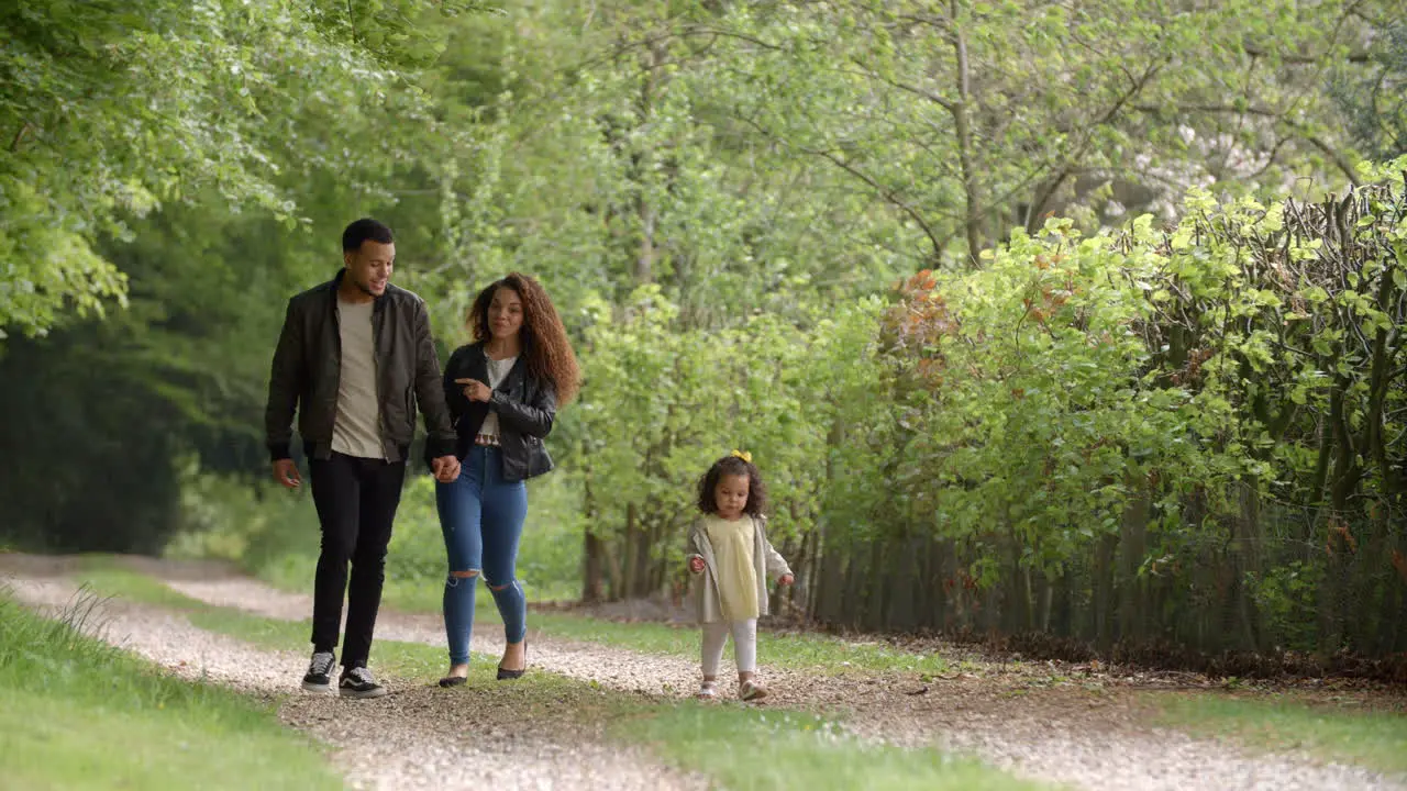 Couple talk during a country walk with their young daughter