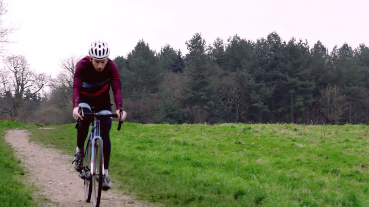 Cross-country cyclist riding down a path in open countryside shot on R3D