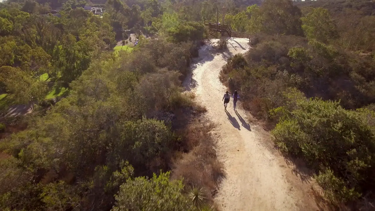 Mother hiking with daughter on empty path aerial shot