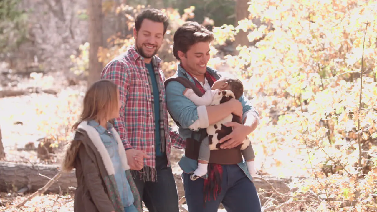 Male parents baby and daughter walking in woods close up