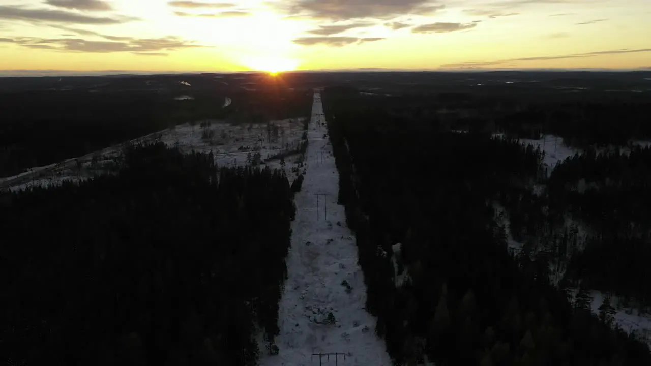 Drone footage flying along power lines during a stunning sunset on a cold winter evening in Sweden