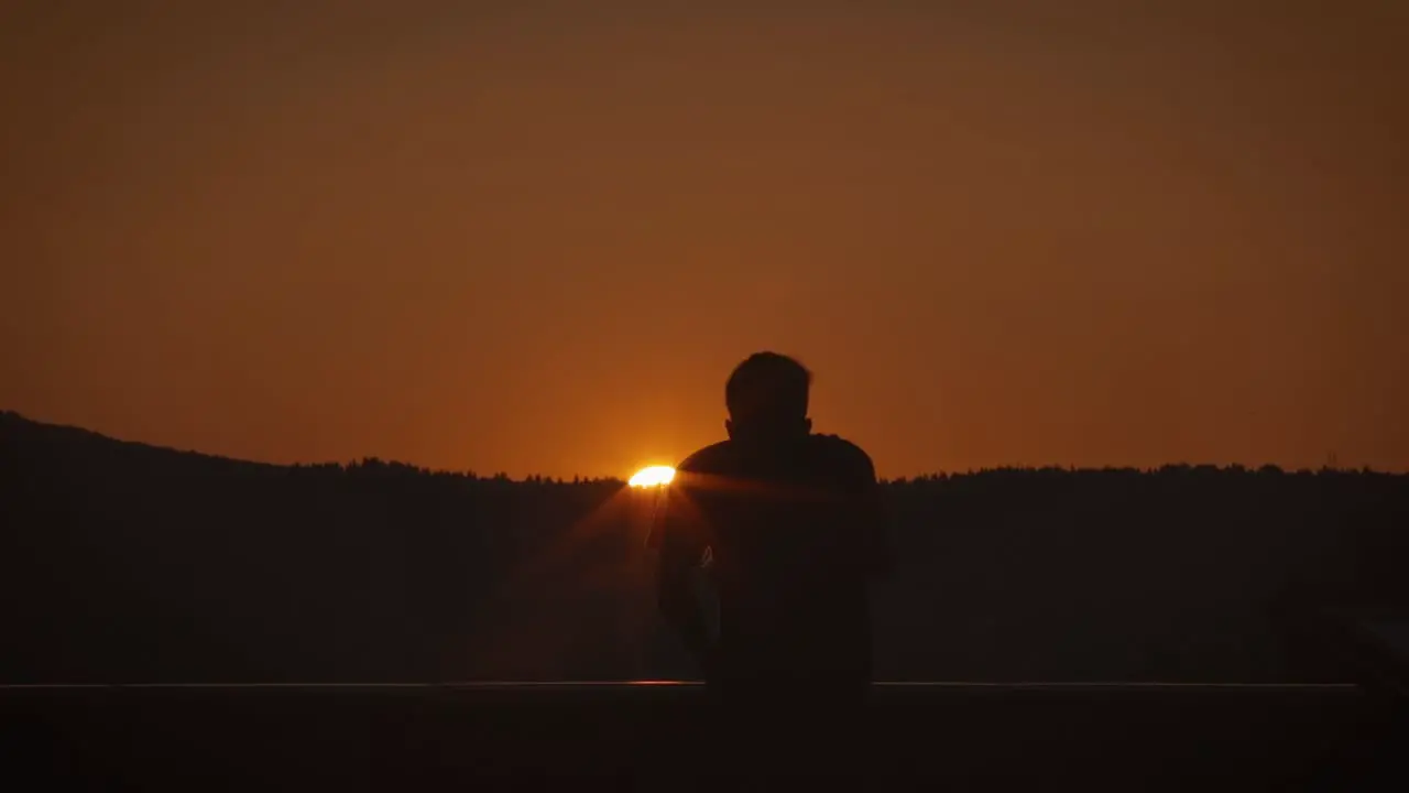 Silhouette Man Using Telescope at Sunset Or Sunrise