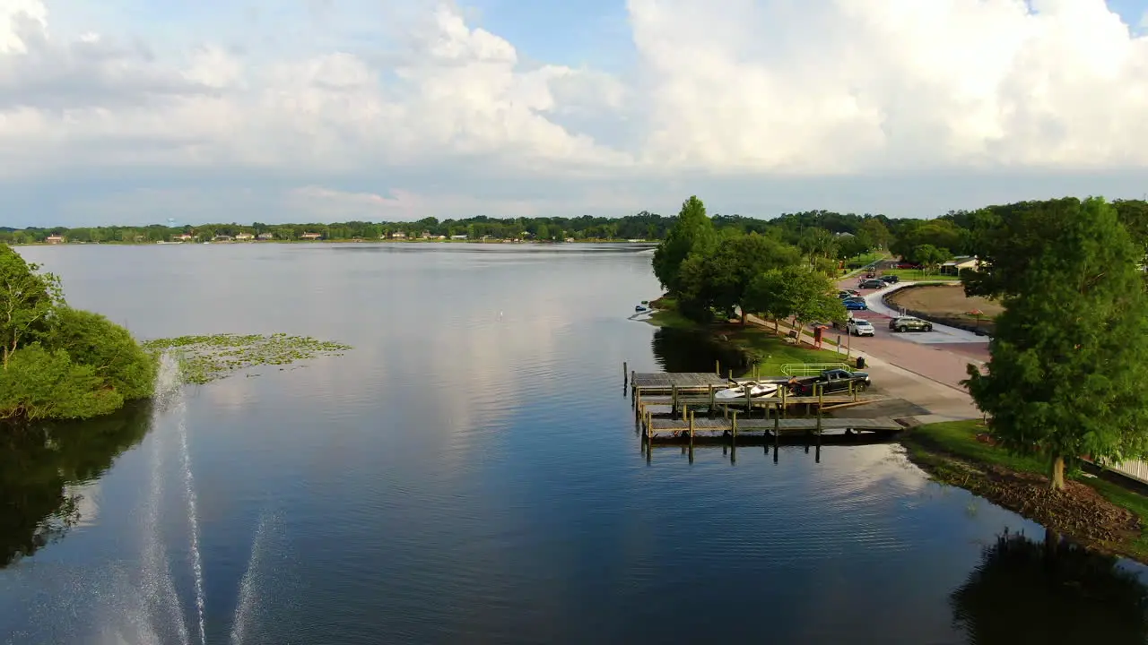 Pan over a beautiful Central Florida Lake with docks and a fountain on a Spring Evening