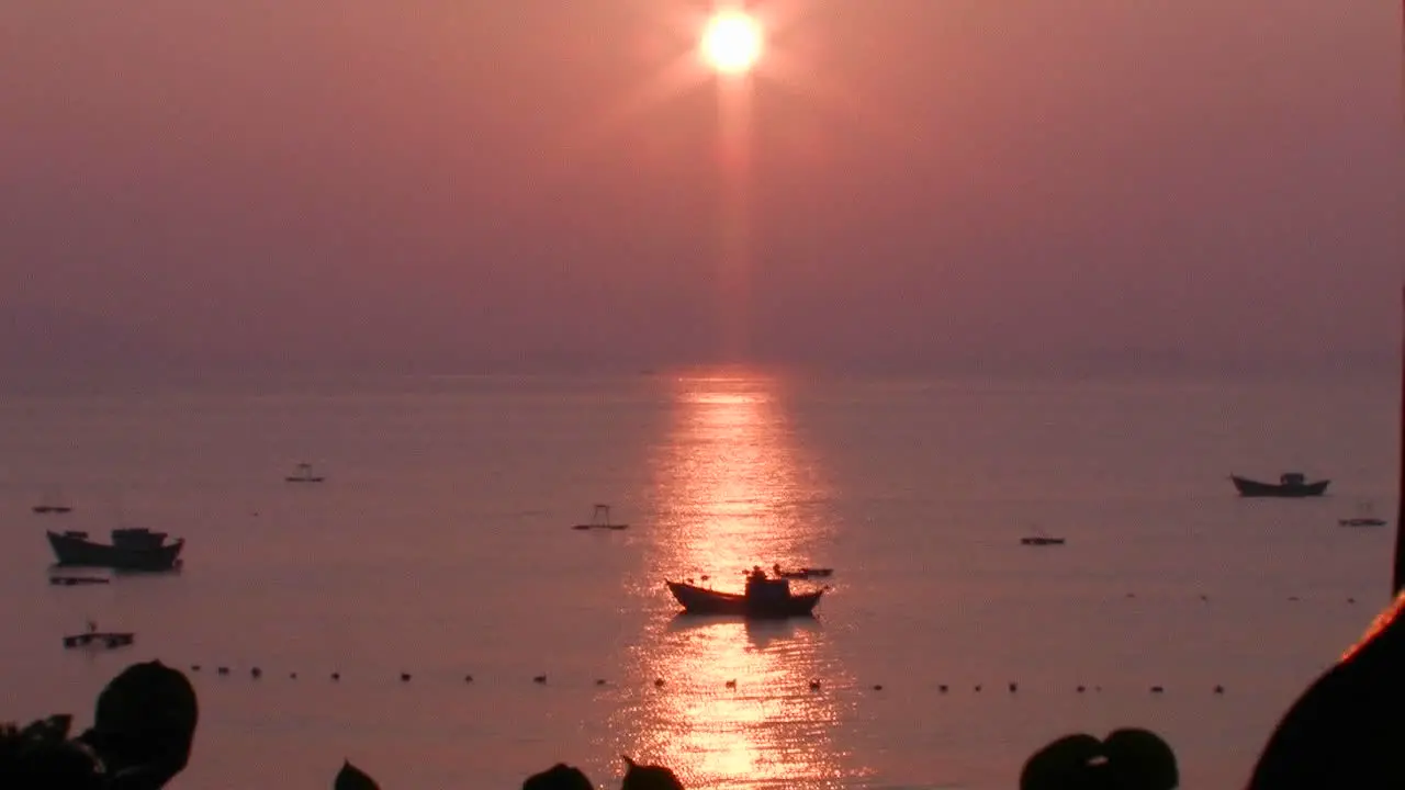 A small boat at sea at sunset in an Asian marina