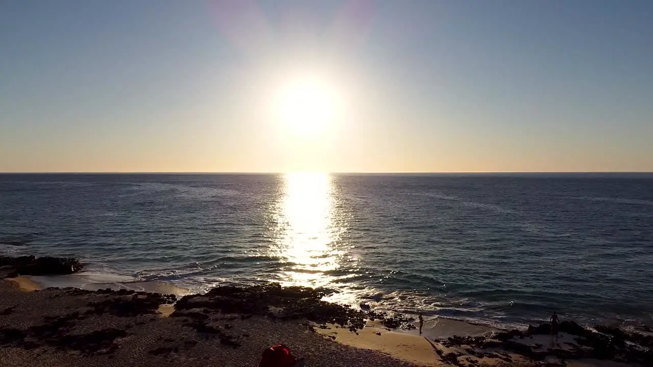 Aerial drone shot of a tent on a beach at sunset