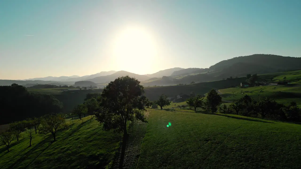 Left to right truck flight in a beautyful swiss landscape during sunrise while birds fly by