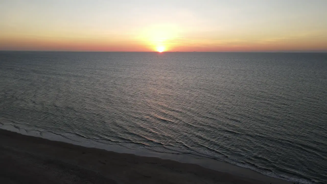 Slow moving Aerial drone shot of Orange sunset and Blue ocean at Lee Point Beach in Darwin Northern Territory