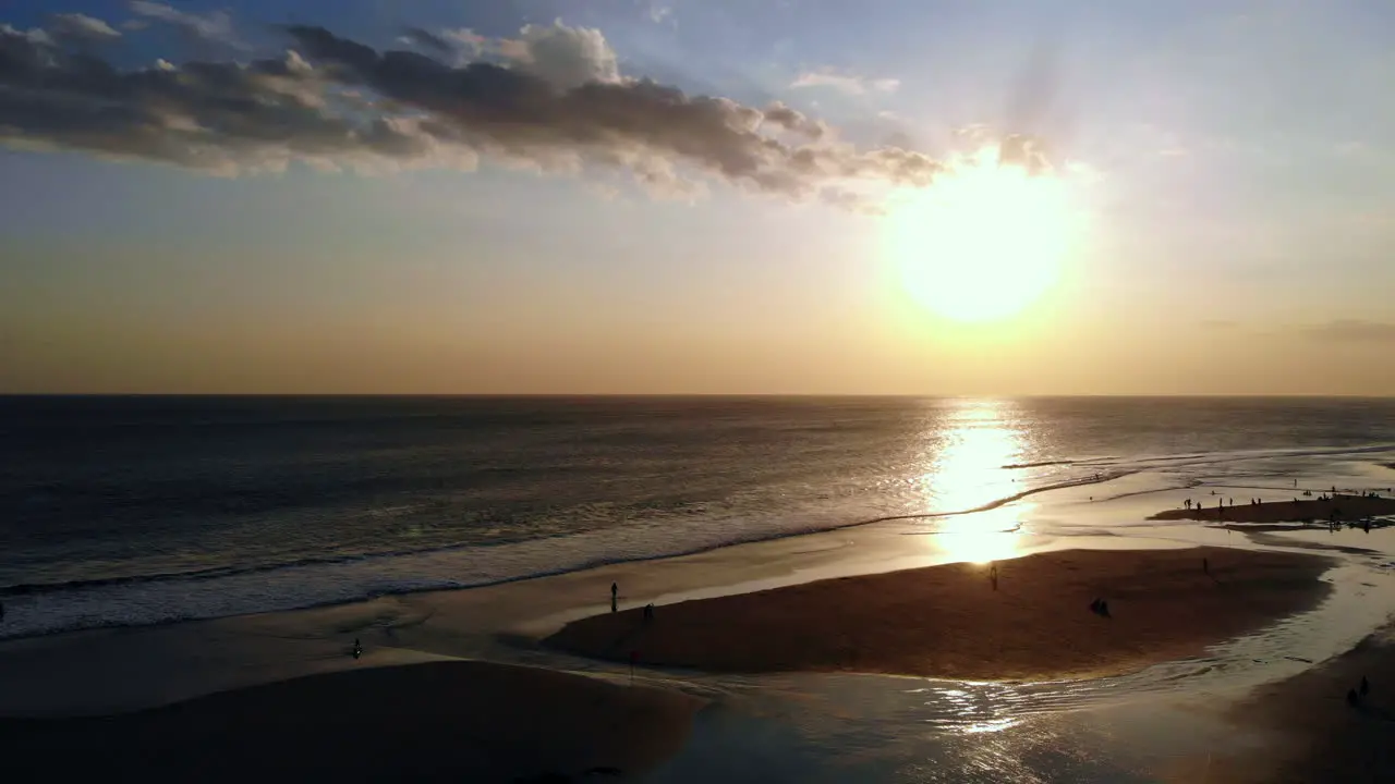 Ascending while looking at the incredible sunset at a sand beach filled with people