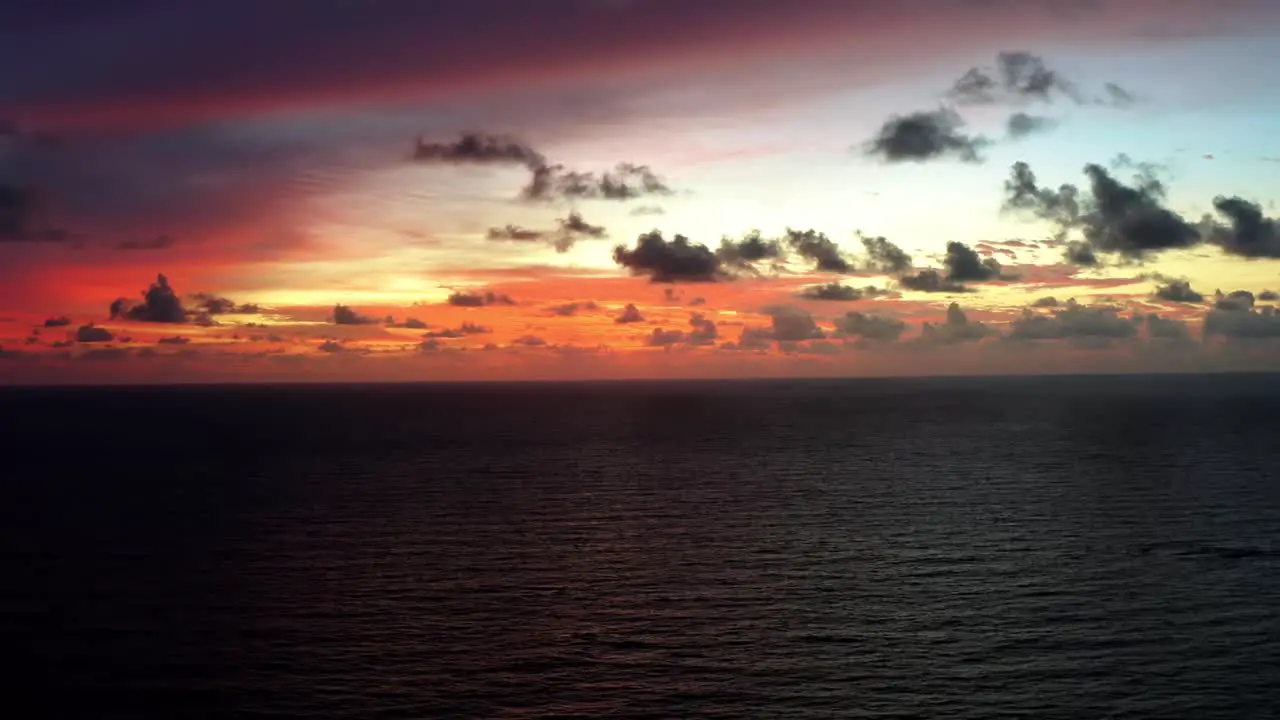 Aerial drone shot of a stunning golden pink and orange sunrise with the vast ocean below on a warm summer morning in Northern Brazil near Joao Pessoa