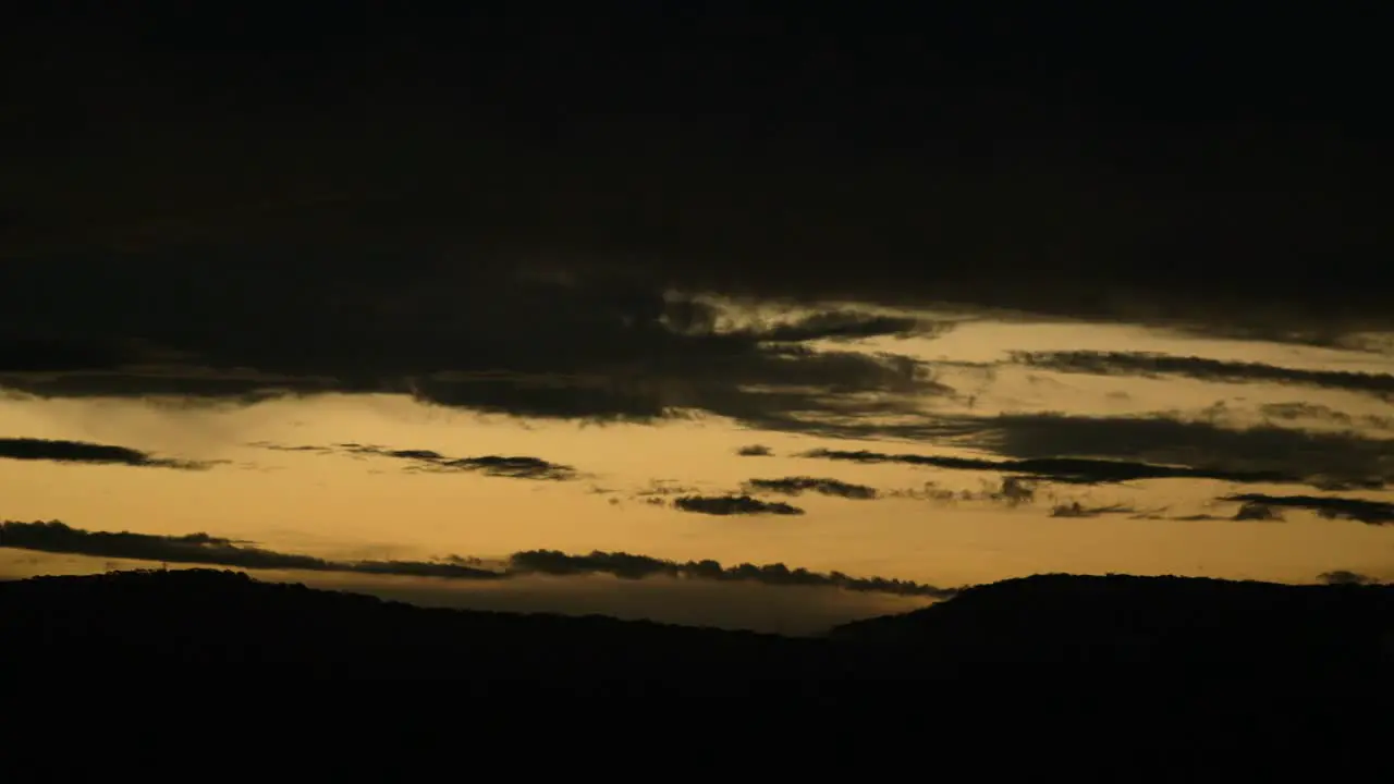 Beautiful Sunset and Silhouette of the hills with clouds rolling by