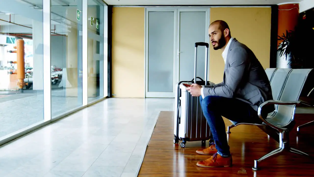 Businessman texting on mobile phone at airport