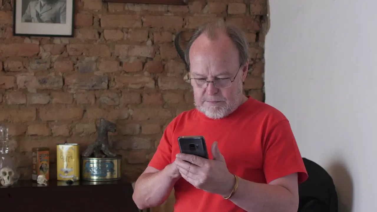 A middle aged man looking perplexed using a smart phone