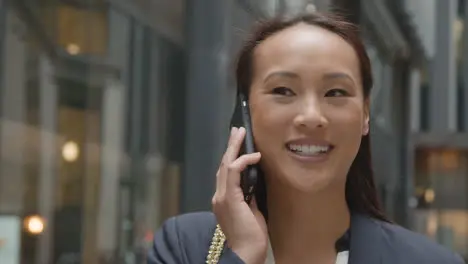 Businesswoman Outside City Of London Offices Talking On Mobile Phone