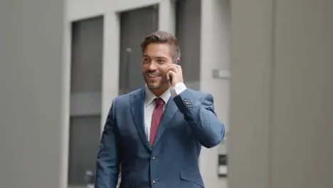 Businessman Outside Office Taking Call On Mobile Phone 3