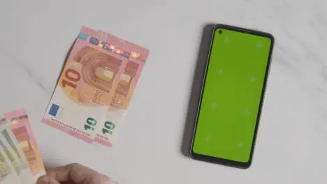 Overhead Currency Shot Person Counting Euro Notes And Coins Next To Green Screen Mobile Phone 1