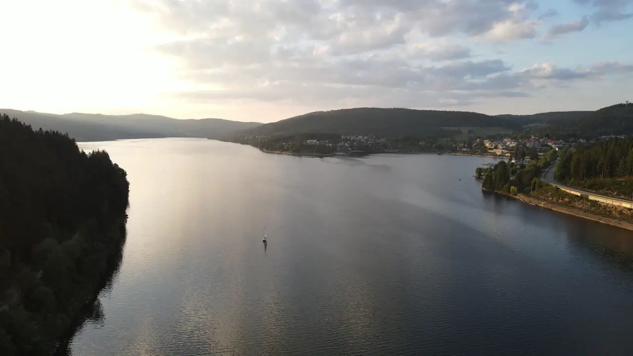 drone filming a small sailing boat at sunset at schluchsee schwarzwald Deutschland