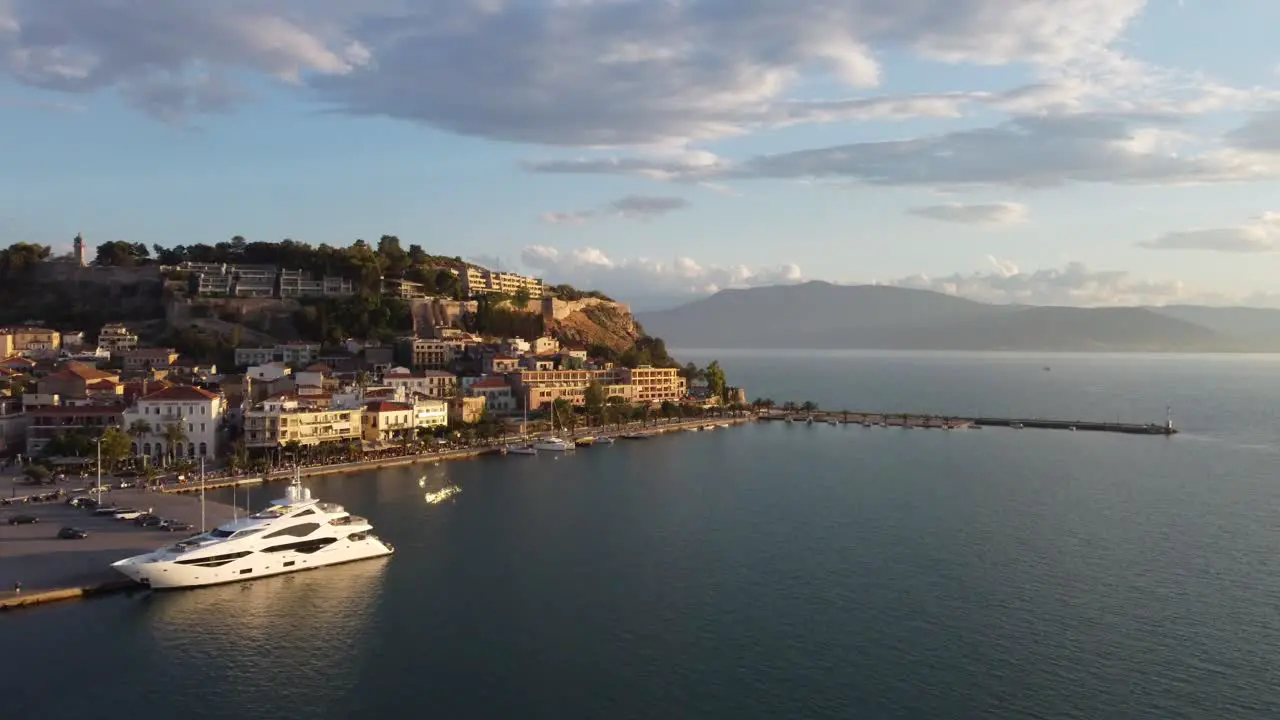 Drone view of the small Mediterranean town of Nauplio in the Peloponnese region of Greece during a cloudy afternoon with yachts in port | 4K